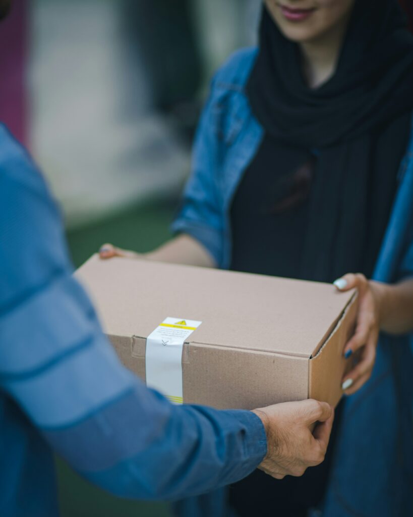 Zoom sur un livreur qui tend un colis à une femme